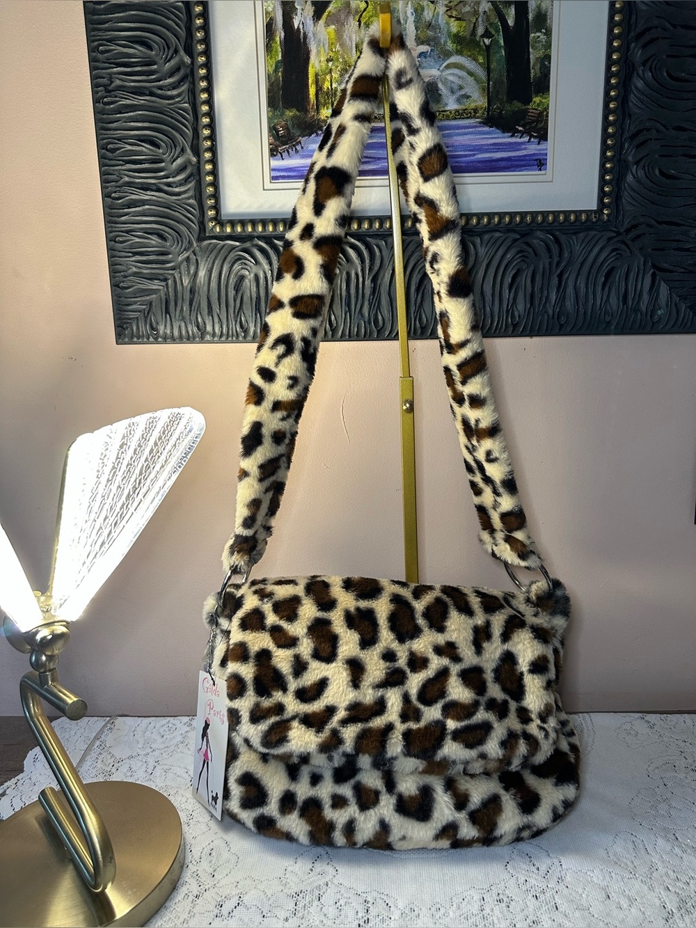 This Gilda Paris faux fur messenger bag features a bold leopard print pattern